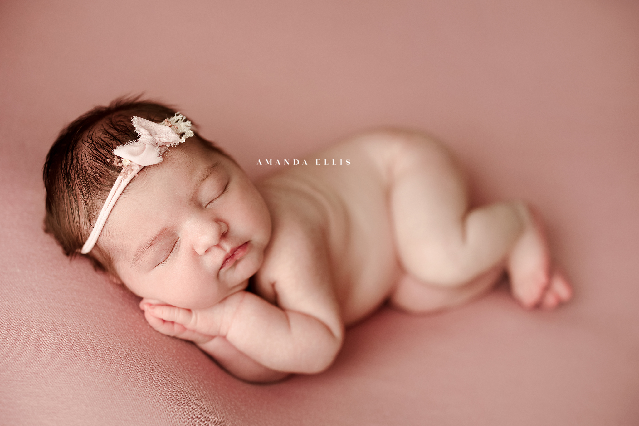 Newborn girl on pink with pink headband