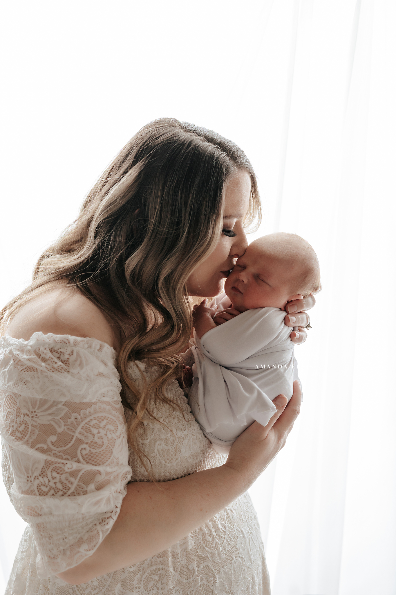 mom kissing her newborn baby girl