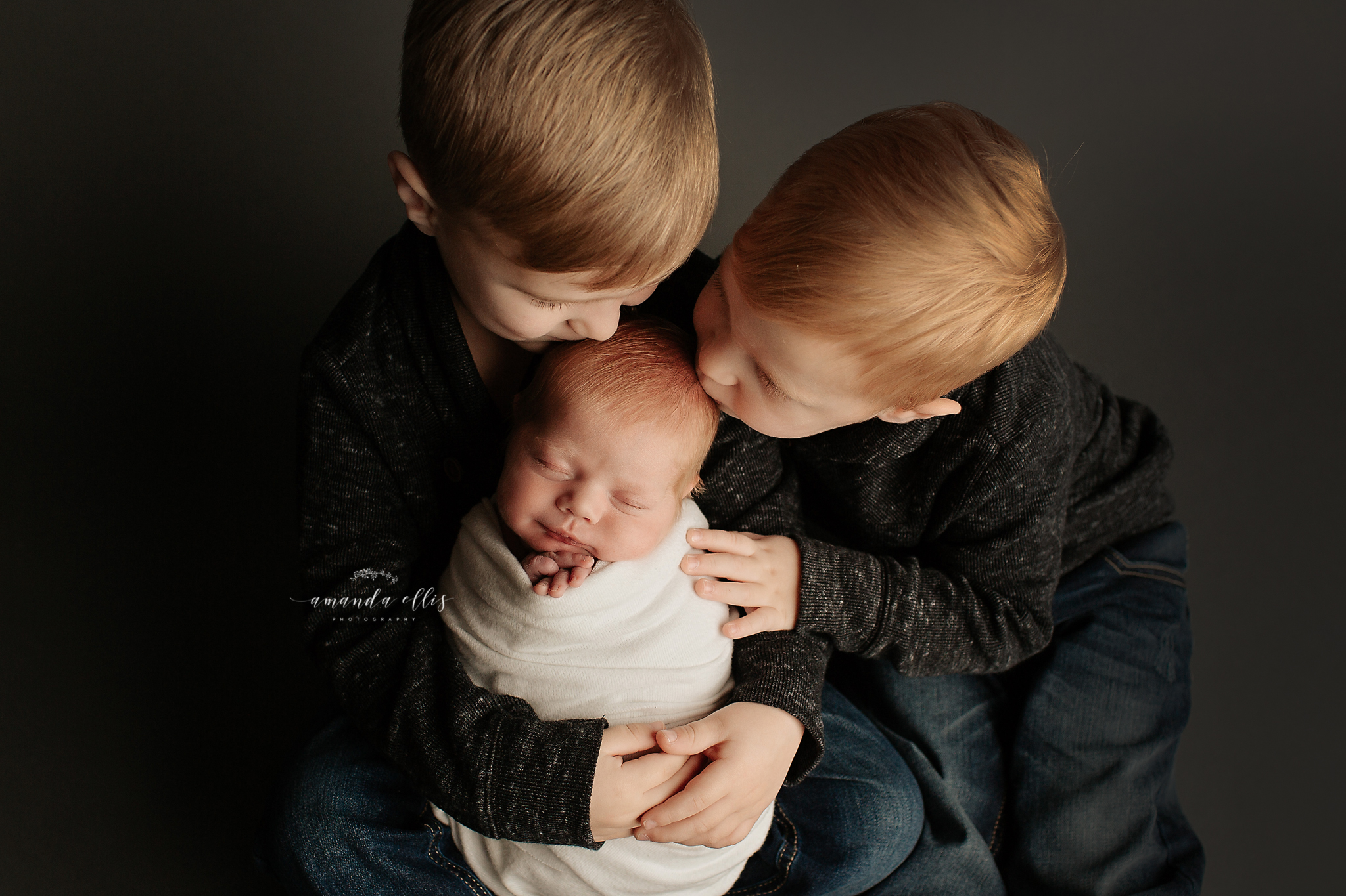 big brothers loving on their new baby brother